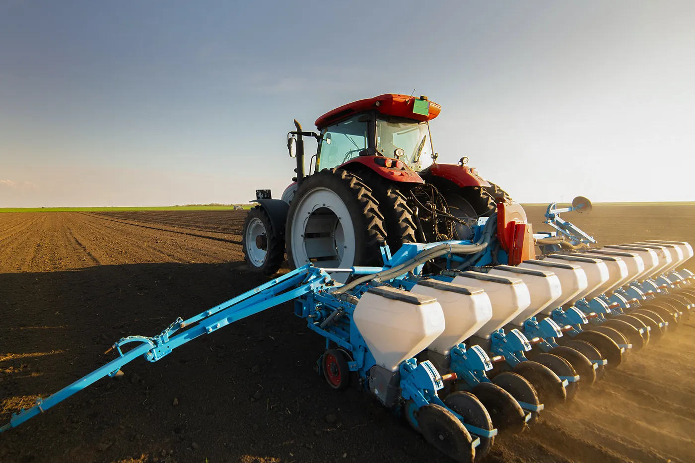 Tracteur agricole équipé d'un semoir dans un champ